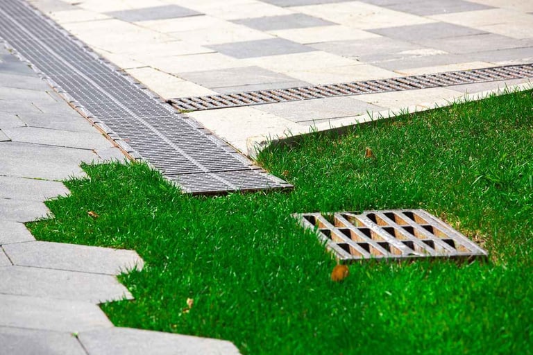 Metal drain grates on green grass
